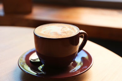 Photo of Aromatic coffee on wooden table in cafe, closeup