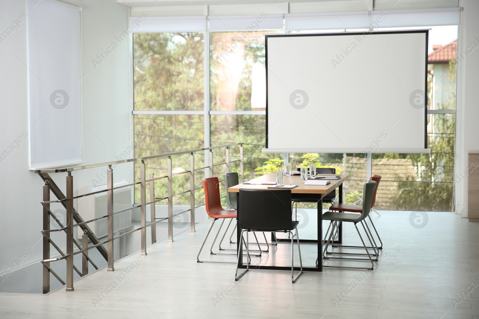 Photo of Modern meeting room interior with large table and projection screen