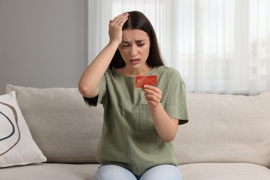 Photo of Stressed woman with credit card at home. Be careful - fraud