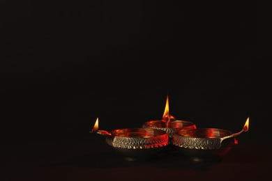 Photo of Diwali diyas or clay lamps on dark background