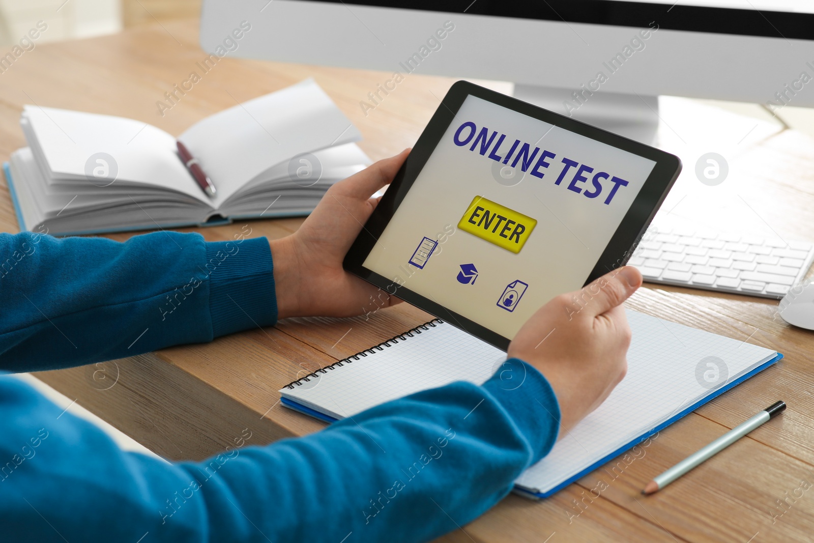 Photo of Man taking online test on tablet at desk indoors, closeup