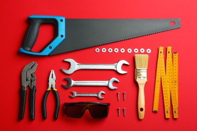 Photo of Flat lay composition with construction tools on color background