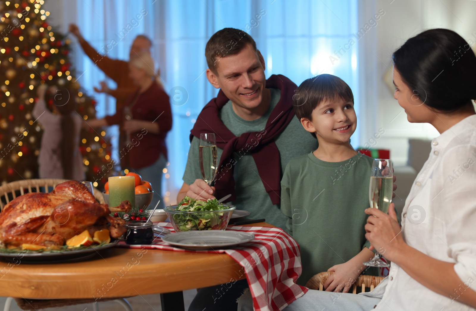 Photo of Happy family celebrating Christmas at home in evening