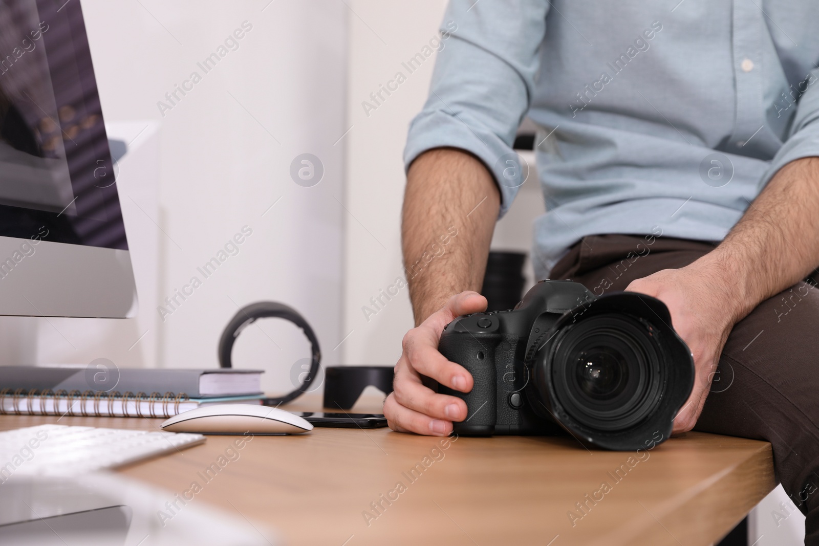 Photo of Professional photographer with camera in office, closeup