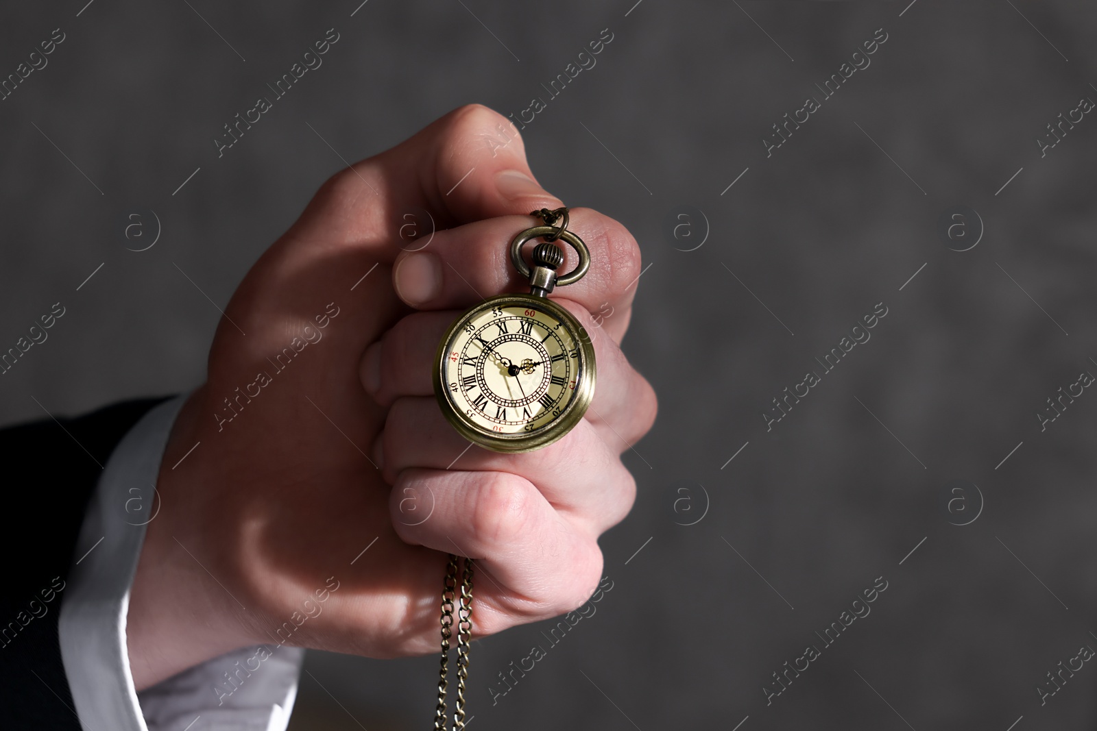 Photo of Man holding chain with elegant pocket watch, closeup. Space for text