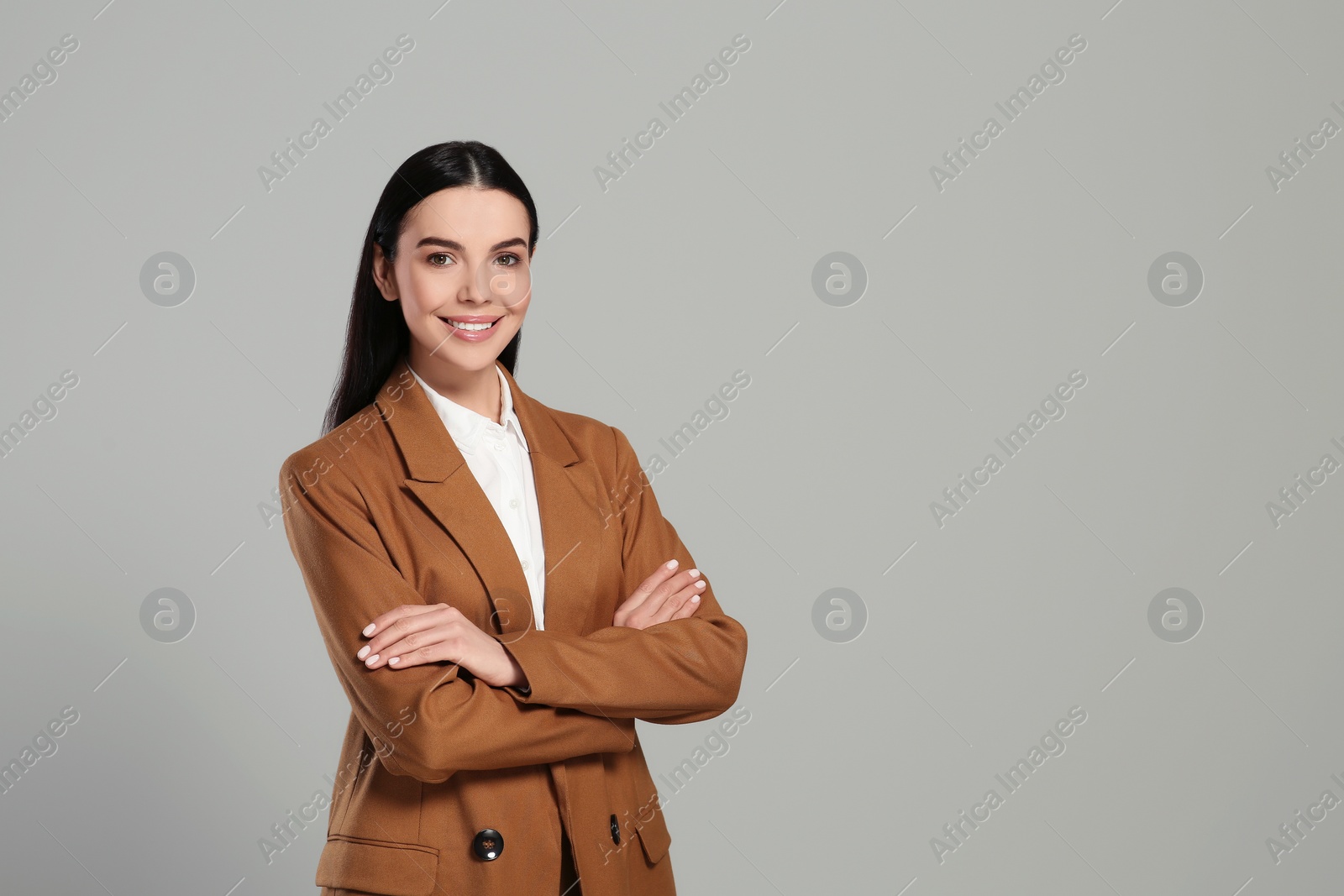 Photo of Beautiful real estate agent in nice suit on grey background, space for text