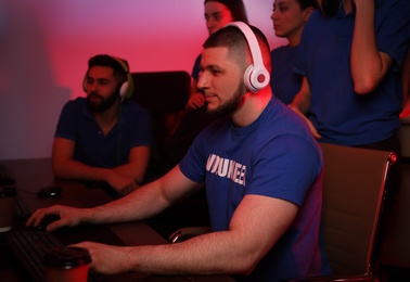 Photo of Young people playing video games on computers indoors. Esports tournament