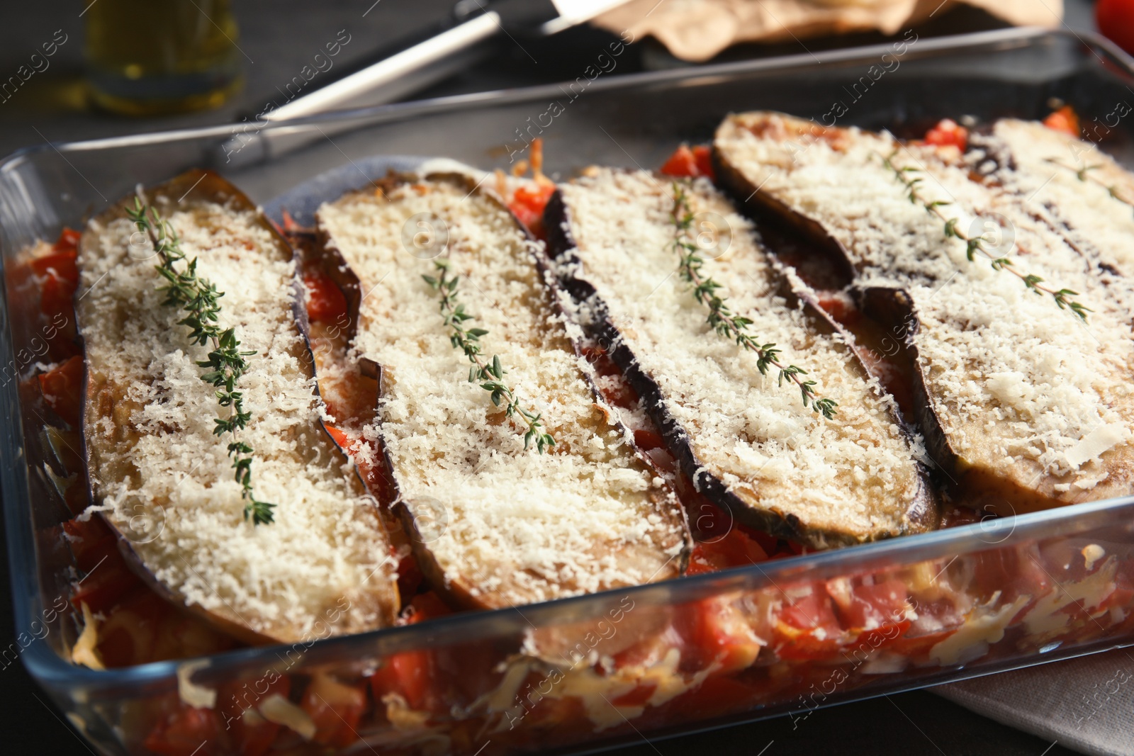 Photo of Baked eggplant with tomatoes and cheese in dishware, closeup