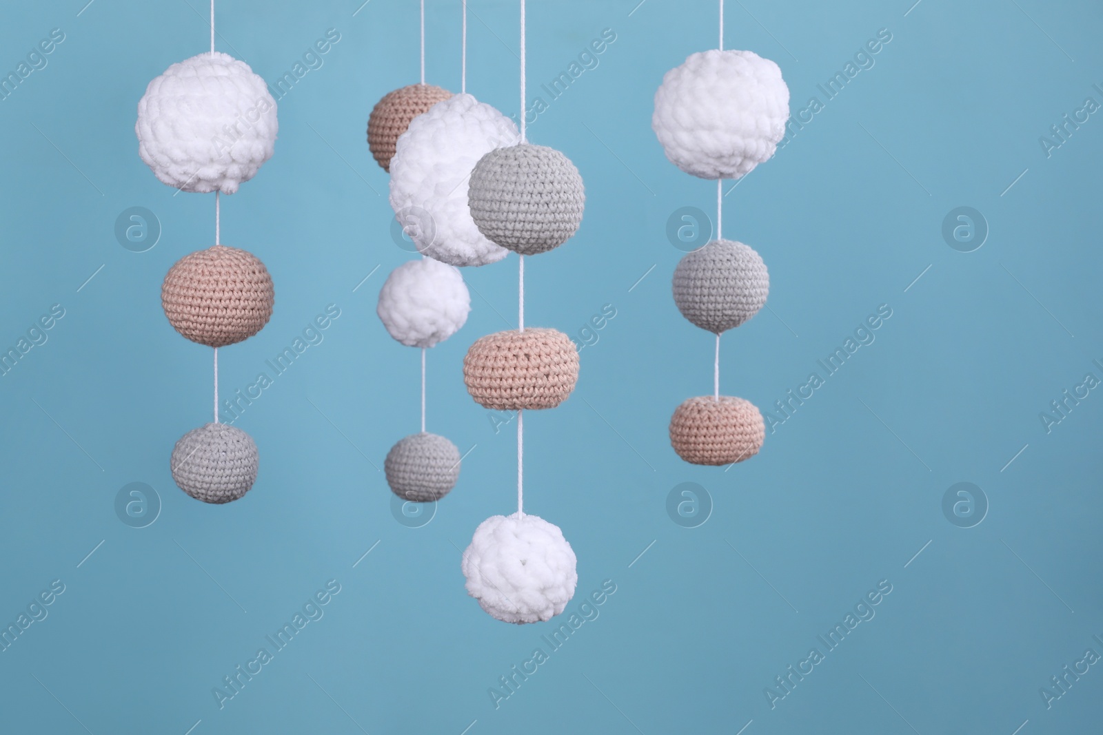 Photo of Cute baby crib mobile on light blue background