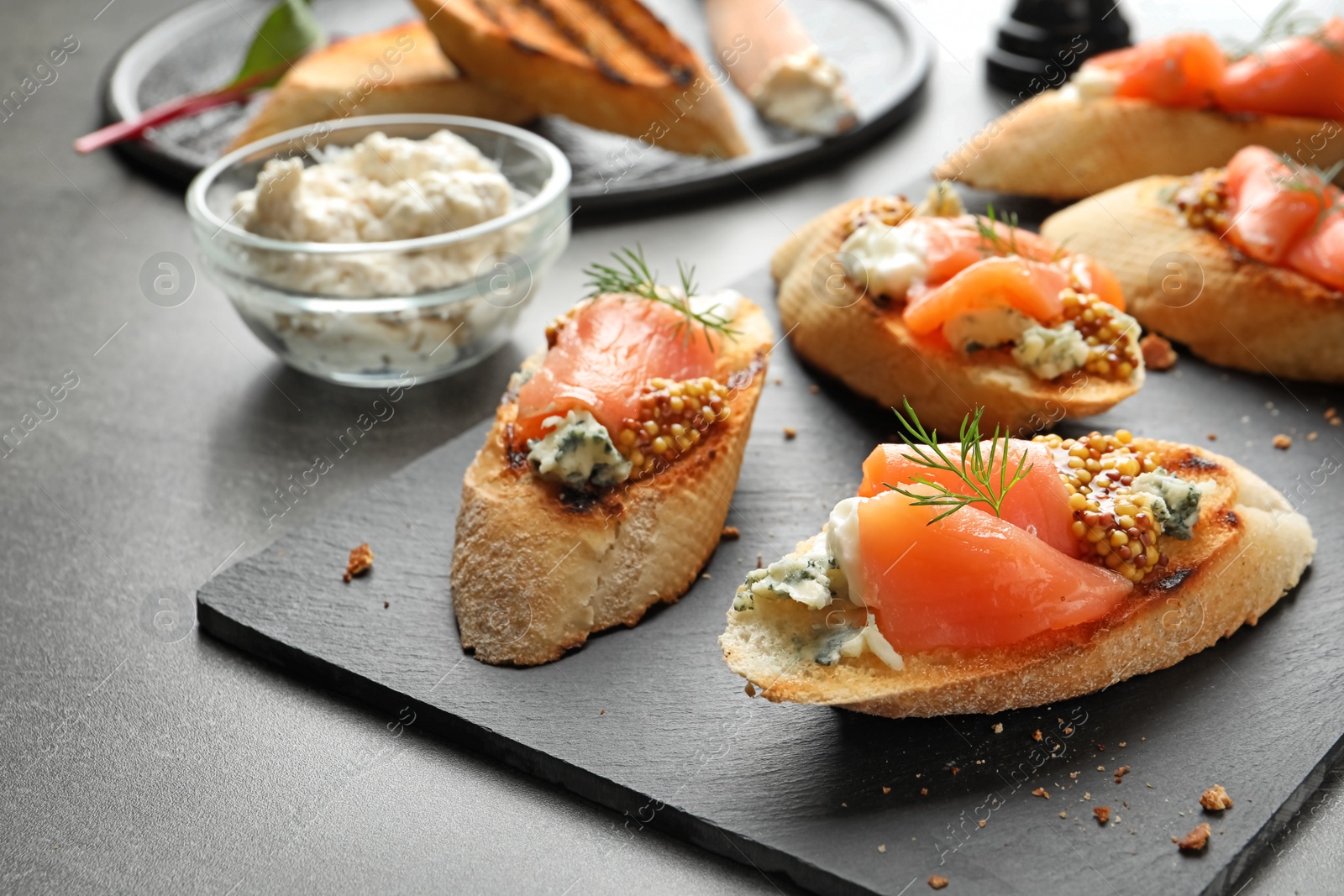 Photo of Tasty bruschettas with salmon and blue cheese served on table. Space for text