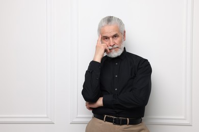 Photo of Portrait of handsome senior man near white wall. Space for text