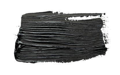 Photo of Brushstrokes of black oil paint on white background, top view