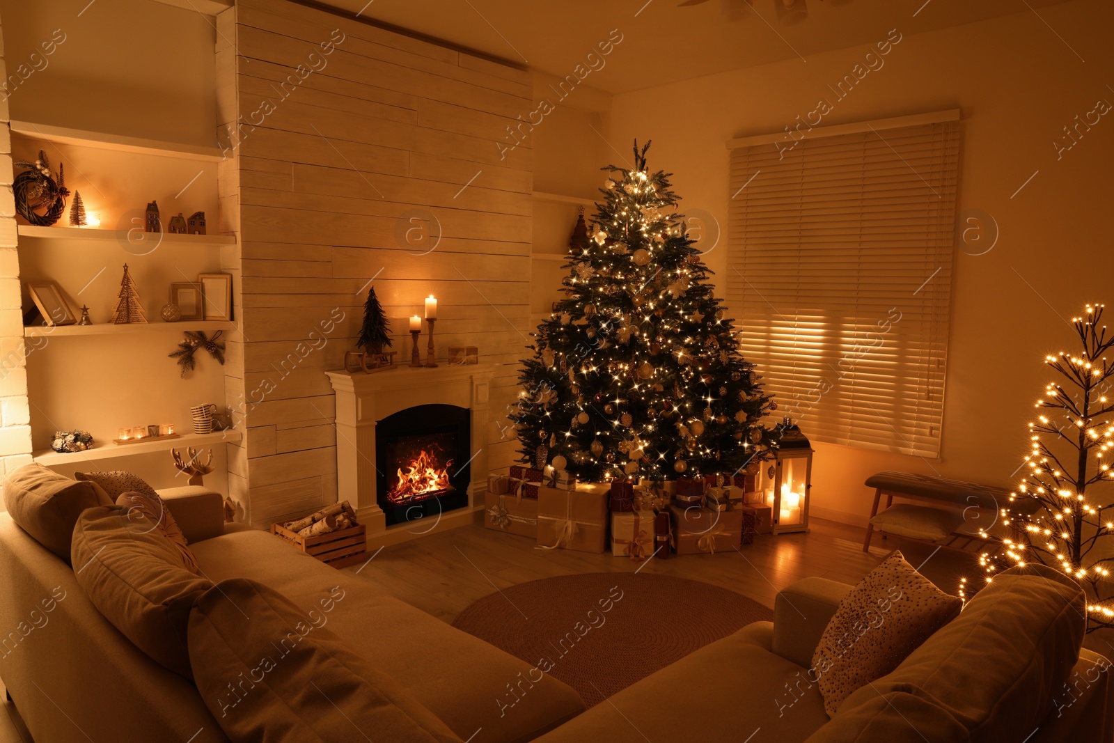 Photo of Beautiful Christmas tree and gift boxes near fireplace in festively decorated living room