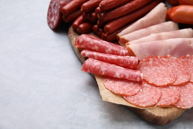 Photo of Different types of sausages on light grey table, closeup. Space for text