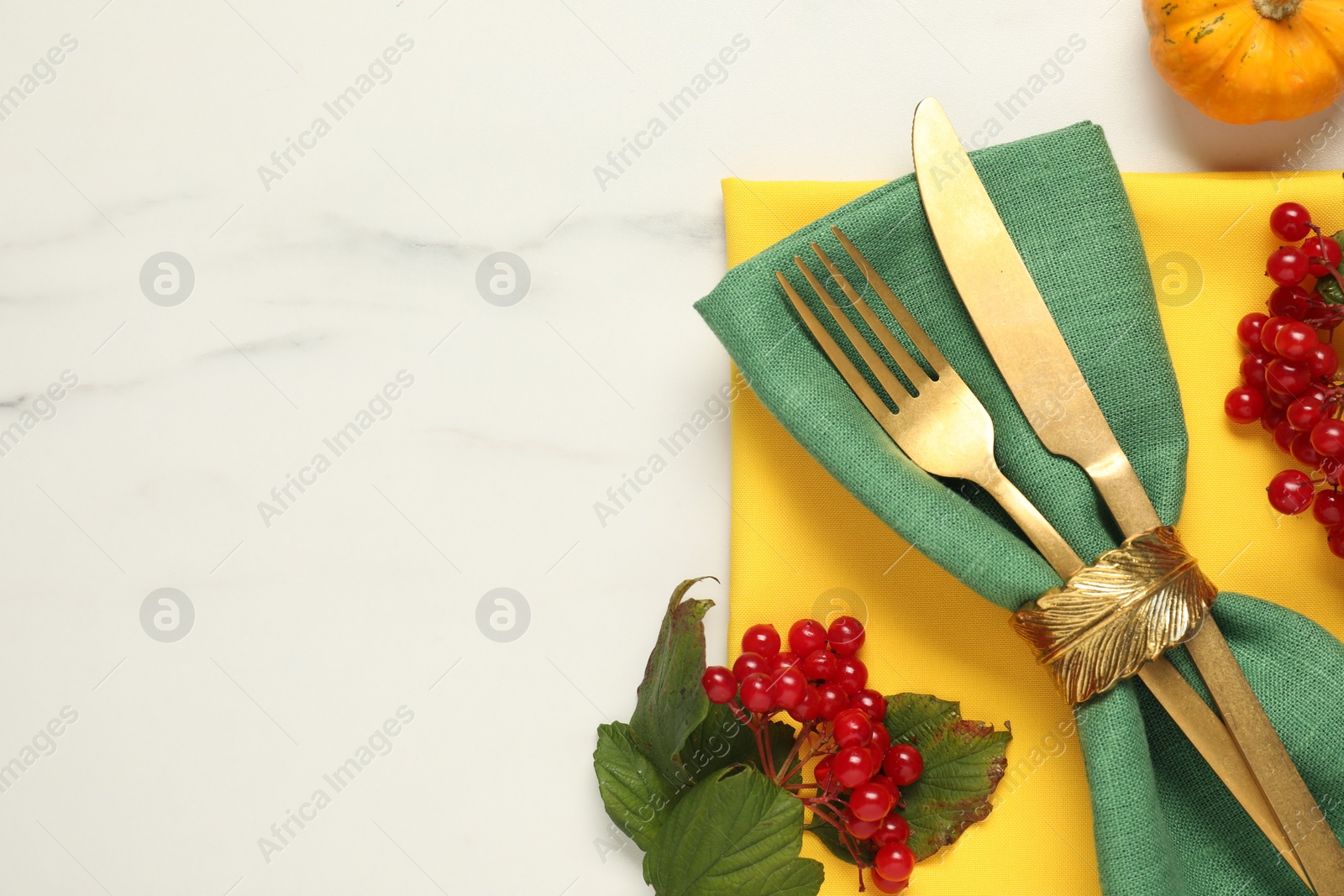 Photo of Autumn table setting. Cutlery, napkins, viburnum berries and pumpkin on white marble background, flat lay with space for text