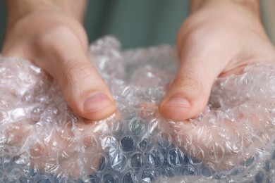 Man popping bubble wrap, closeup view. Stress relief