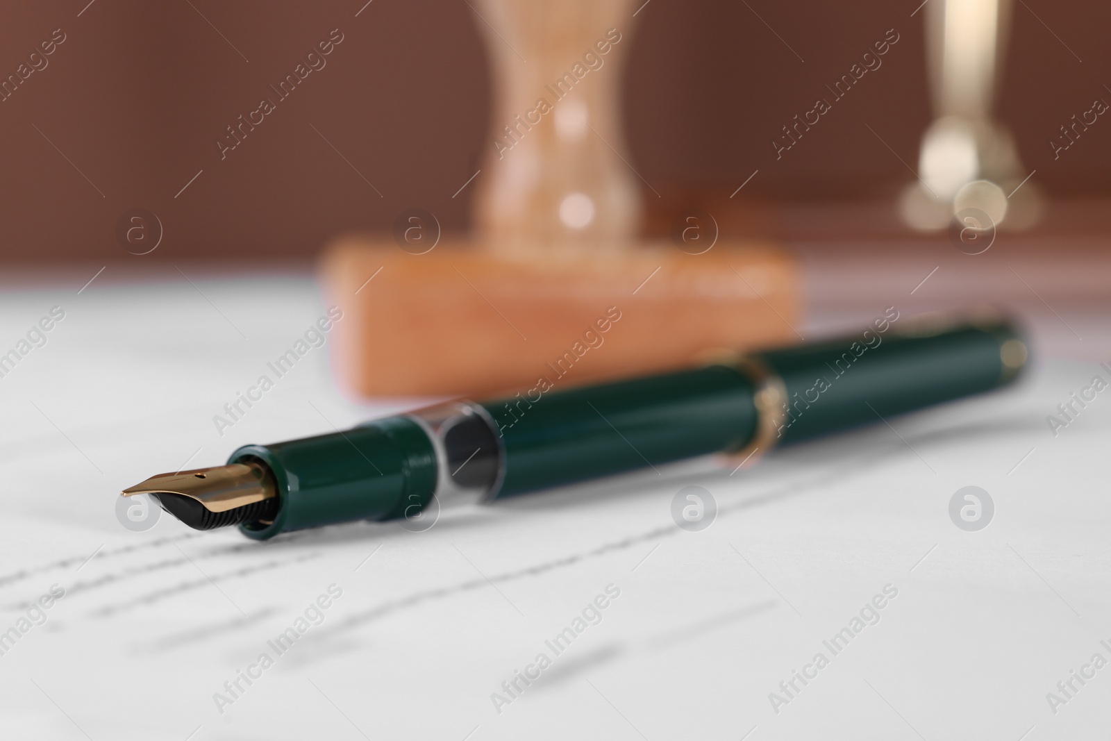 Photo of Fountain pen on paper document, closeup. Notary service