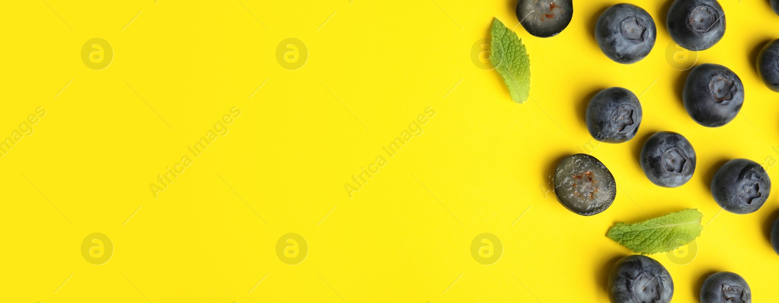 Image of Tasty fresh blueberries on yellow background, top view with space for text. Banner design