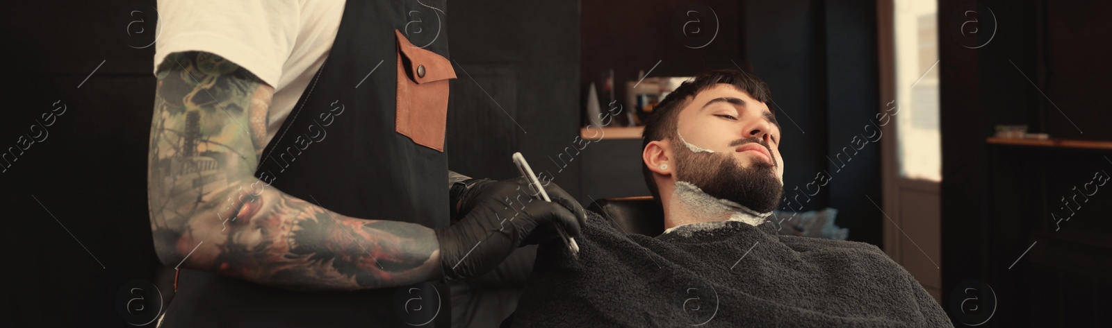 Image of Professional hairdresser working with bearded client in barbershop. Banner design