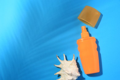 Photo of Sunscreen and seashell on light blue background, flat lay and space for text. Sun protection care