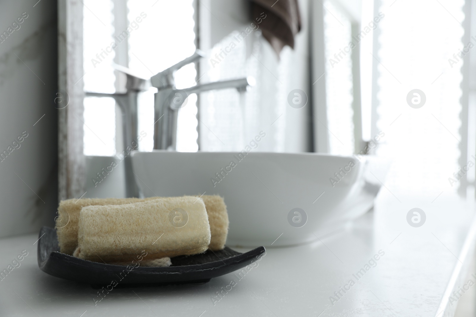 Photo of Loofah sponges on table in bathroom. Space for text