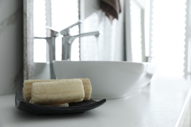 Photo of Loofah sponges on table in bathroom. Space for text