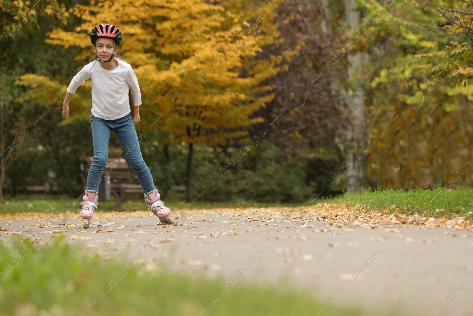 Photo of Cute girl roller skating in autumn park. Space for text