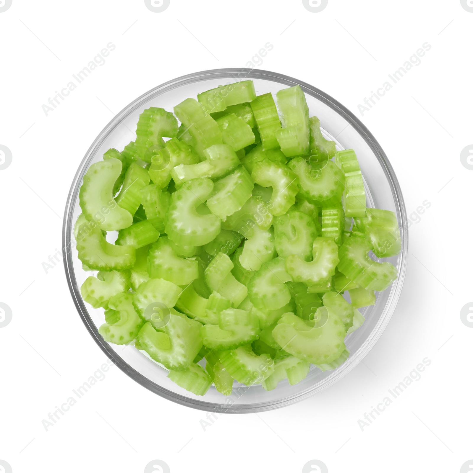 Photo of Glass bowl of fresh cut celery isolated on white, top view