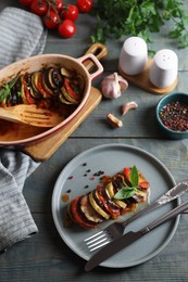 Delicious ratatouille served with basil on grey wooden table, above view