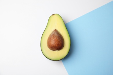 Photo of Cut fresh ripe avocado on color background, top view