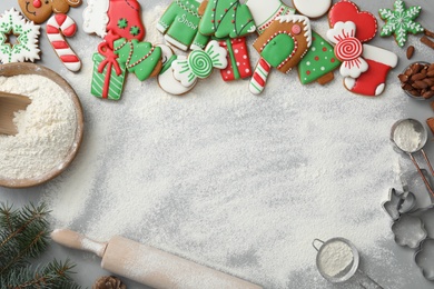 Photo of Delicious homemade Christmas cookies and flour on grey table, flat lay. Space for text