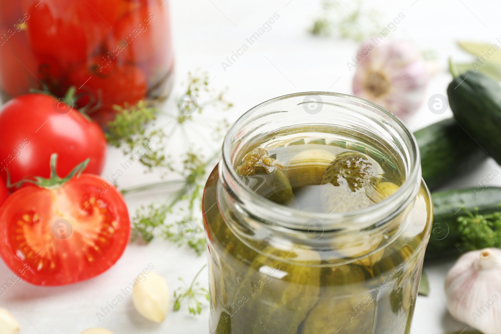 Photo of Glass jar of pickled cucumbers on table, closeup. Space for text