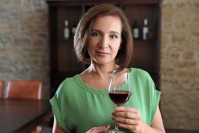 Photo of Woman with glass of red wine indoors
