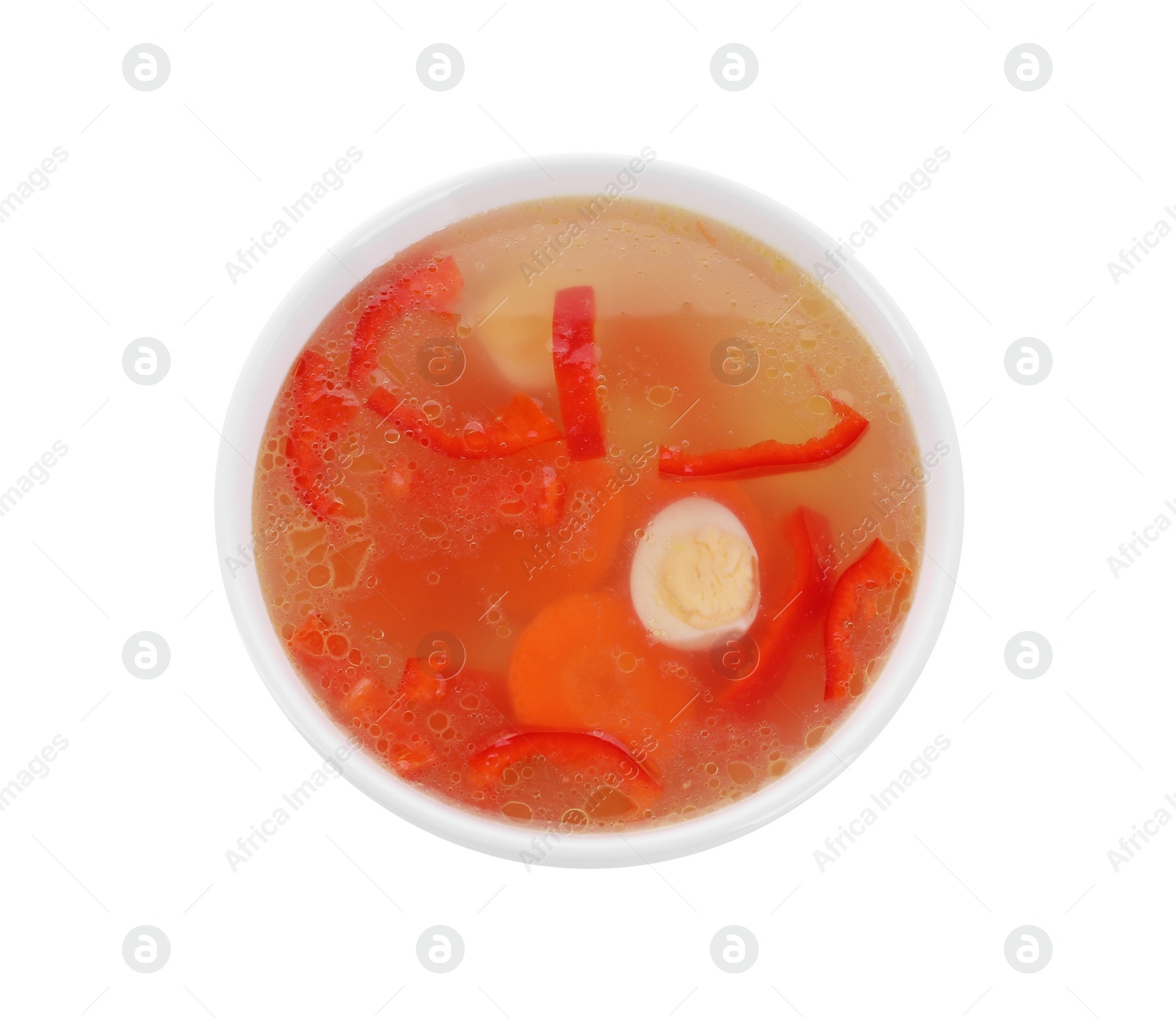 Photo of Tasty soup with egg, bell pepper and carrot in bowl isolated on white, top view