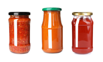 Image of Set with delicious sauces in glass jars on white background
