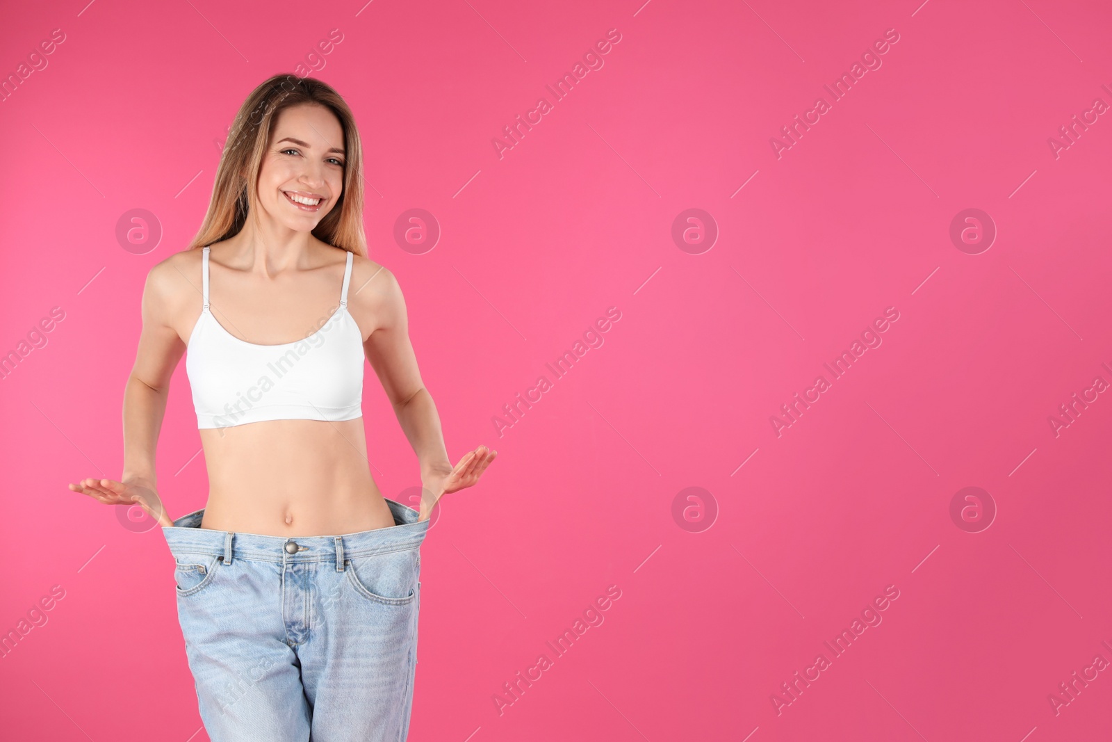 Photo of Slim woman in oversized jeans on color background, space for text. Perfect body