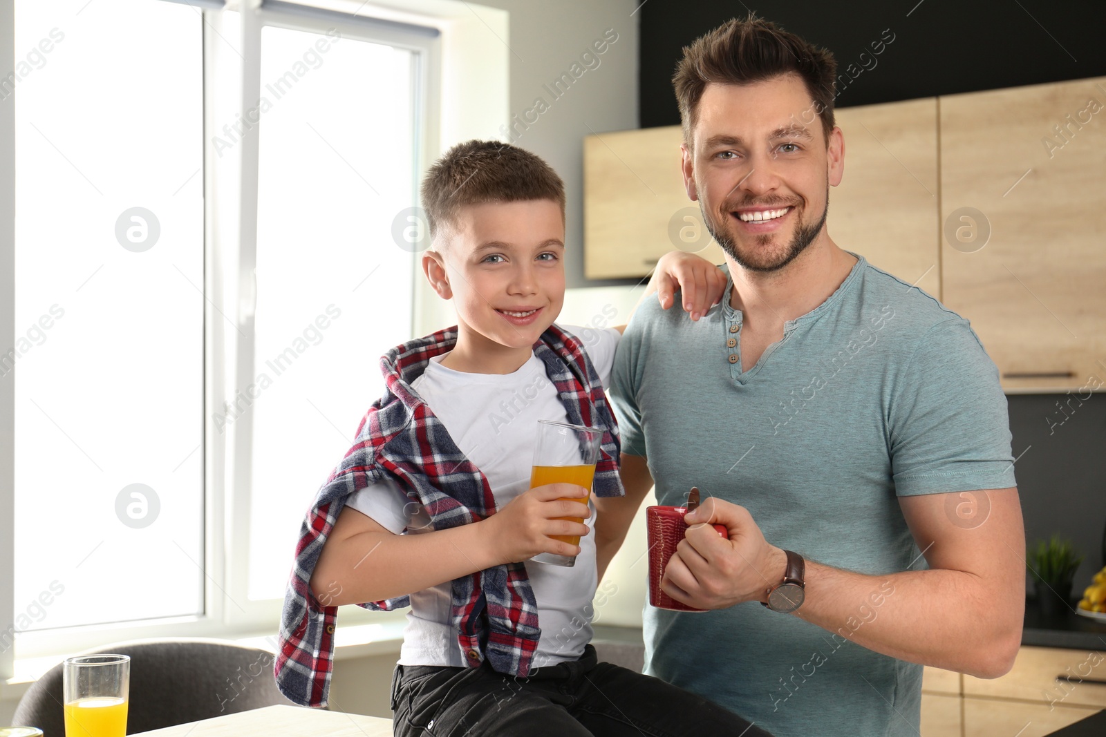 Photo of Dad and son having breakfast together in kitchen