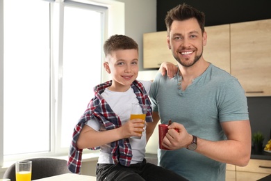 Photo of Dad and son having breakfast together in kitchen