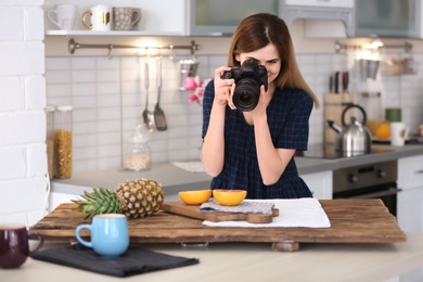 Photo of Young blogger taking photo of food in kitchen