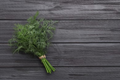 Photo of Bunch of fresh dill on wooden table, top view. Space for text