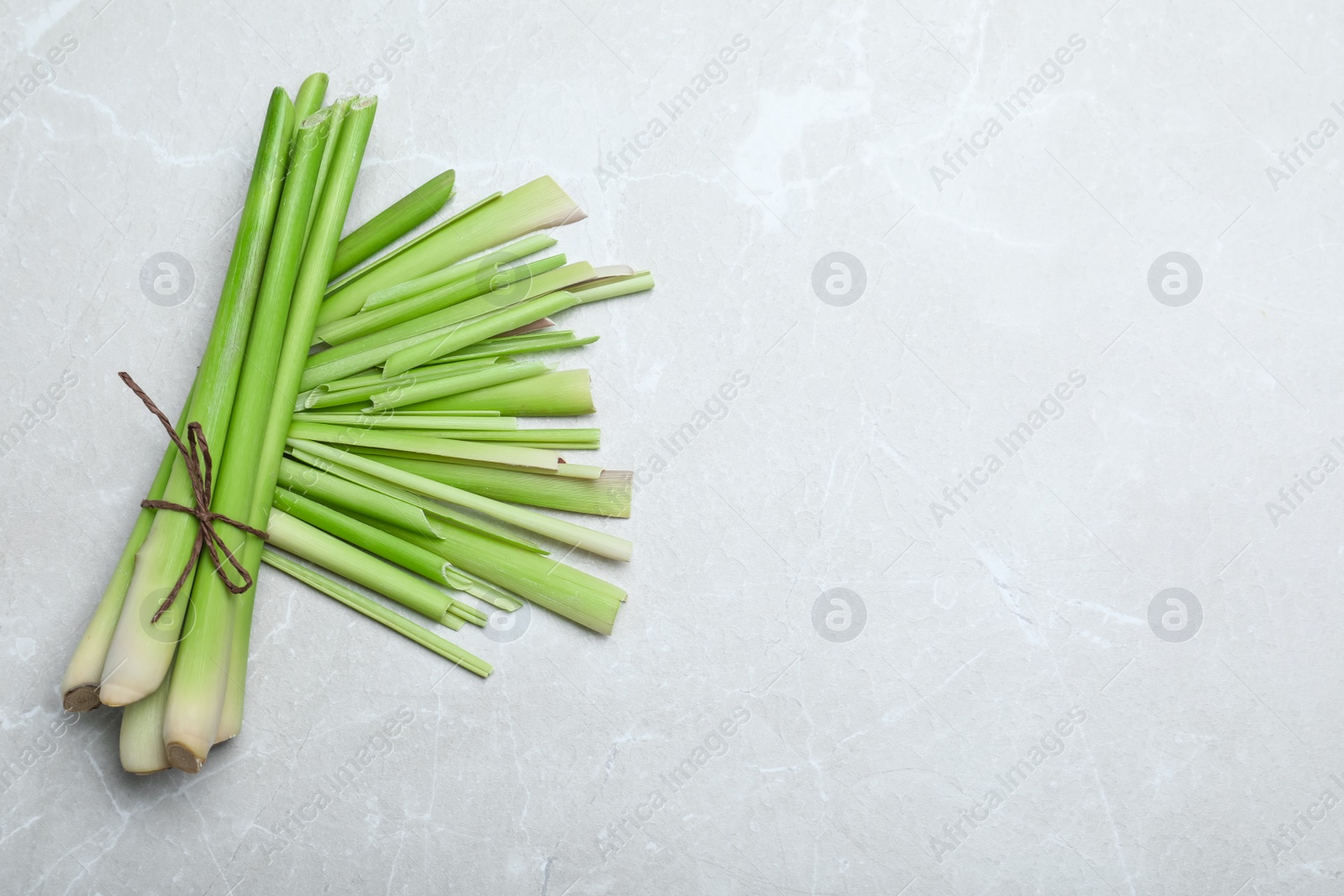 Photo of Bunch of fresh lemongrass on light table, flat lay. Space for text