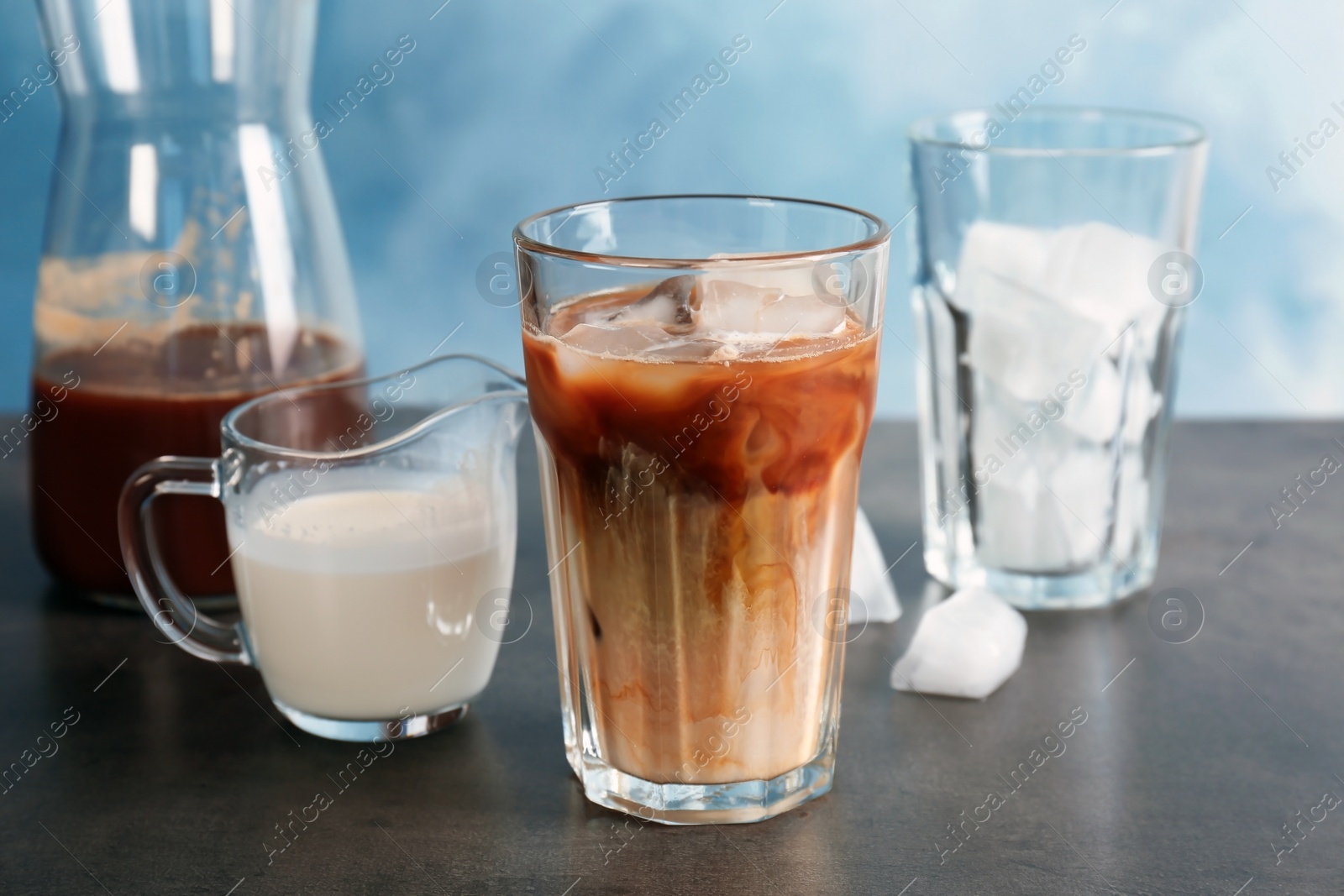 Photo of Glass with cold brew coffee and milk on table