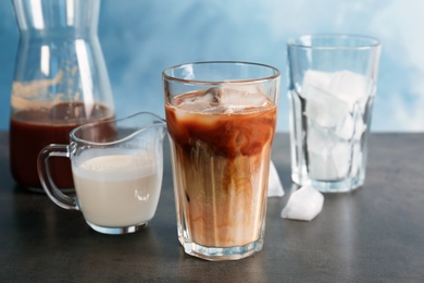 Glass with cold brew coffee and milk on table