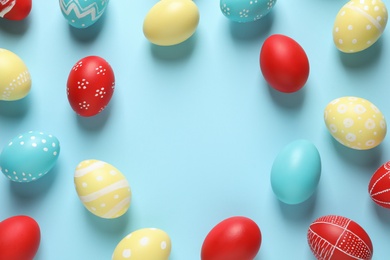 Photo of Flat lay composition with painted Easter eggs on color background, space for text