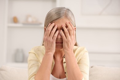 Menopause. Woman suffering from headache at home