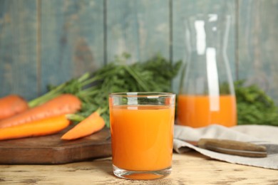 Photo of Glass of freshly made carrot juice on wooden table