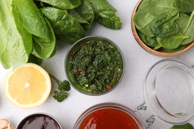 Photo of Different marinades and products on light table, flat lay