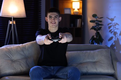 Man playing video games with controller at home