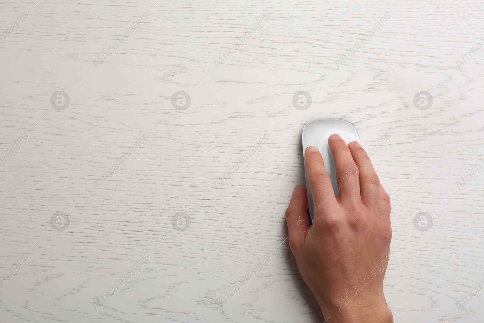 Photo of Man using computer mouse on wooden table, top view. Space for text