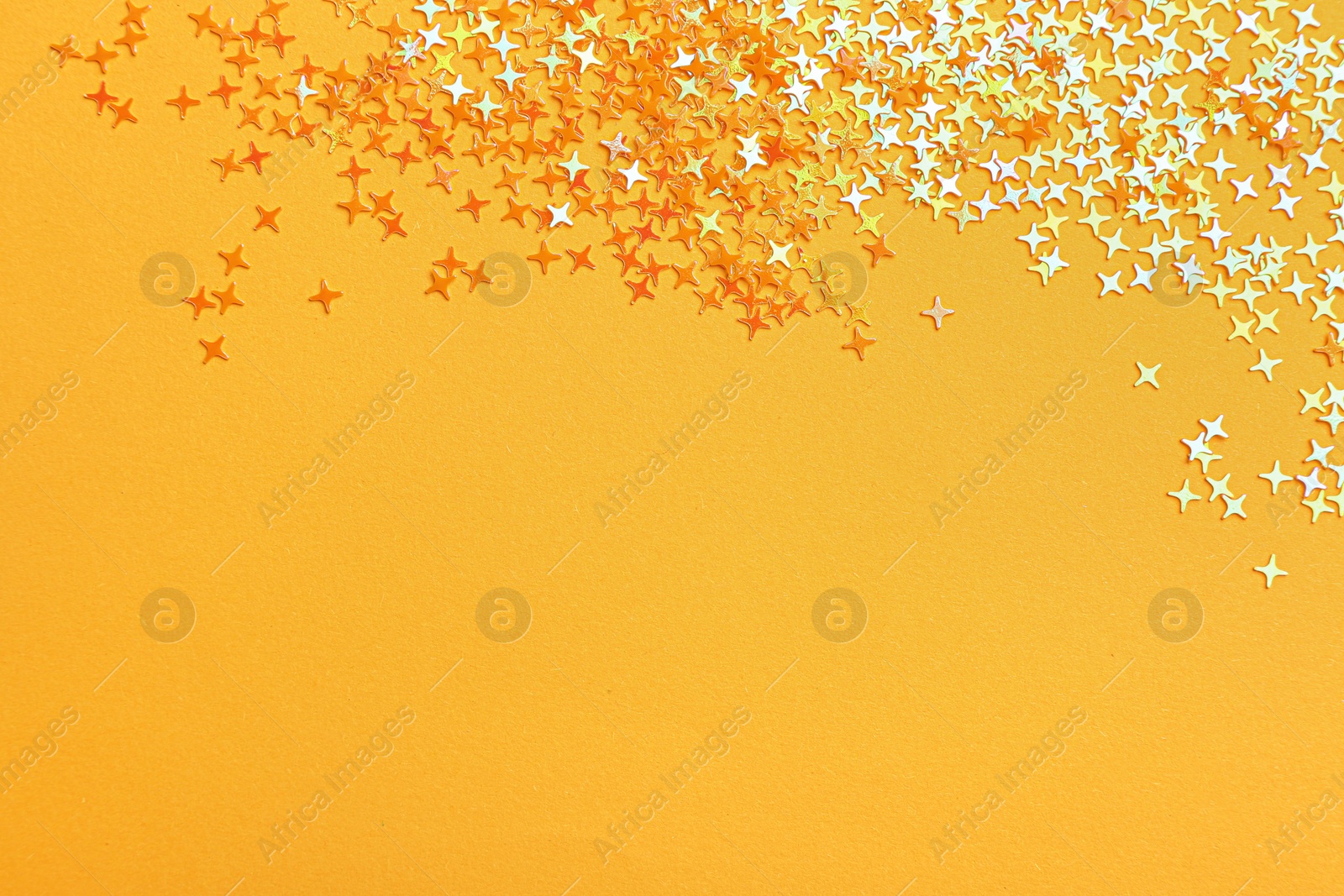 Photo of Shiny bright glitter on light orange background, flat lay. Space for text